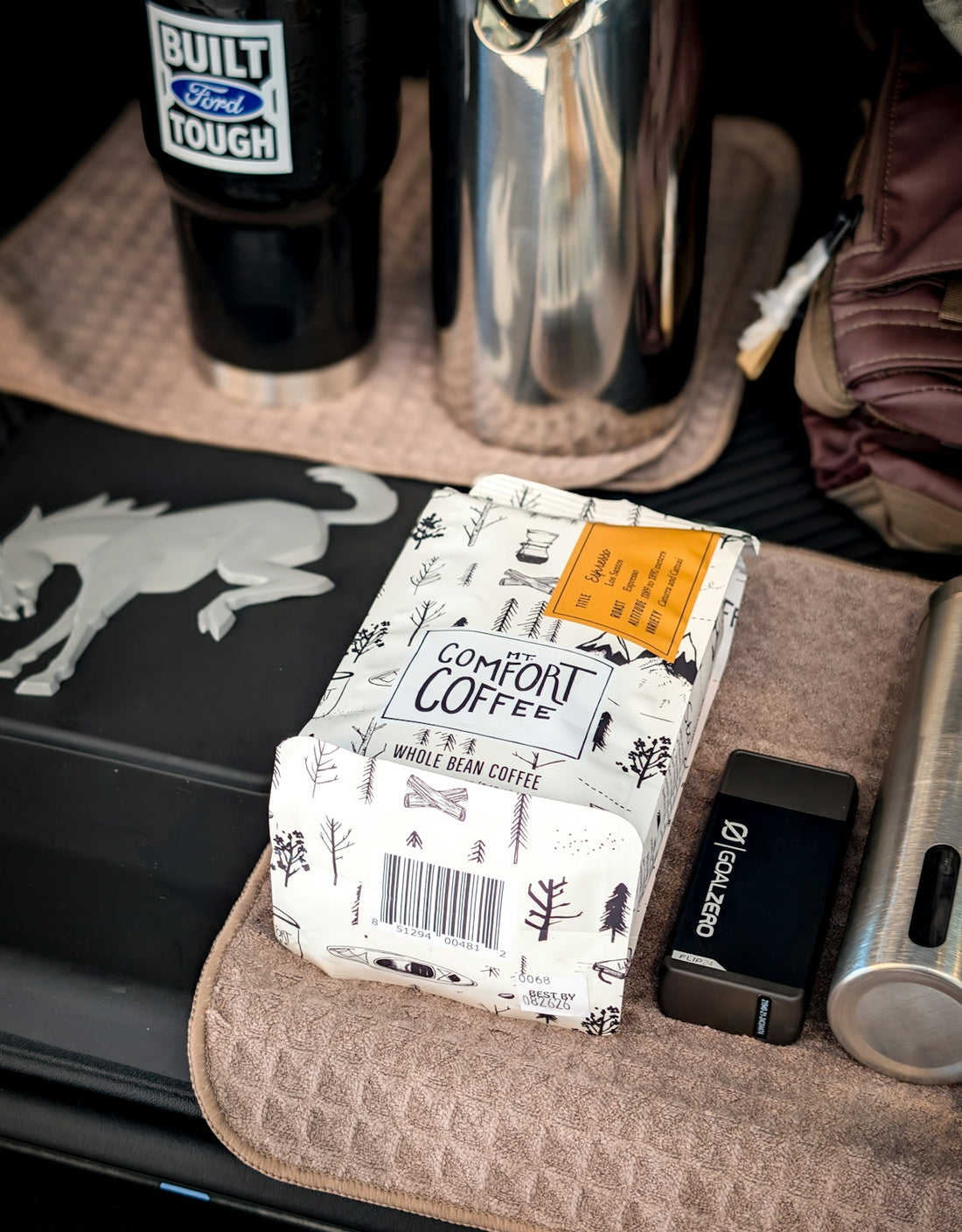 Bag of comfort coffee next to metal thermos and cup