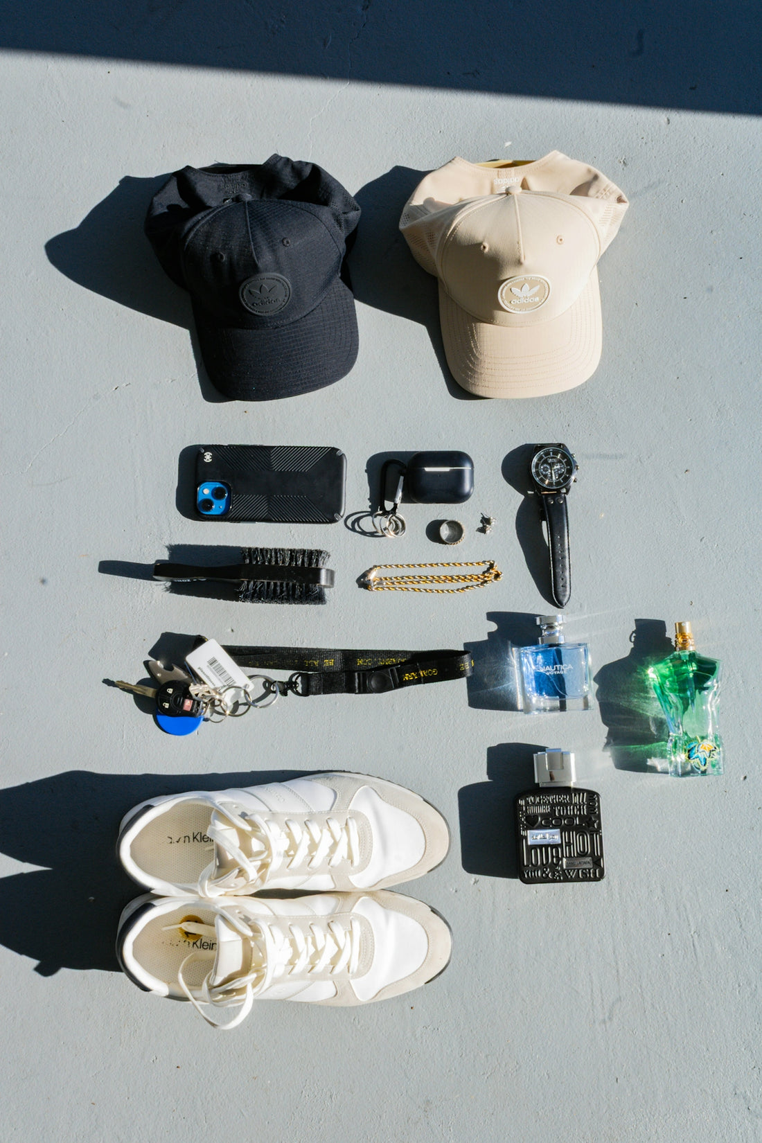 Collection of men's accessories including hats, phone, and cologne